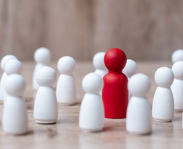 white wooden figures, one is red