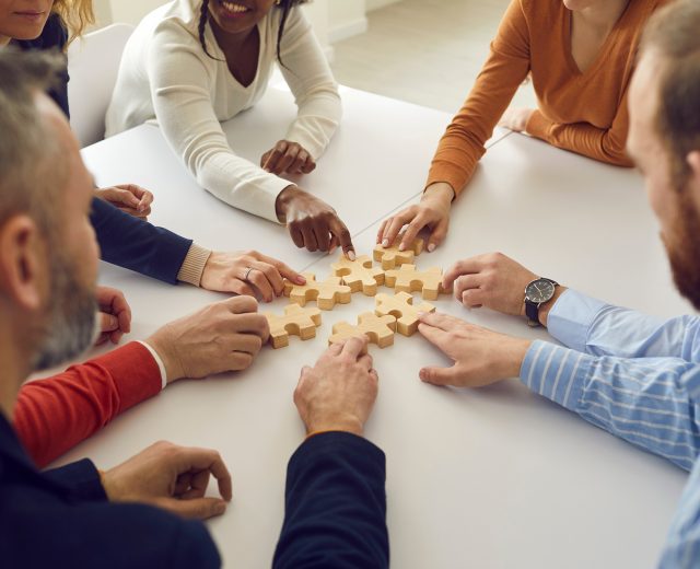 Team placing puzzle pieces together